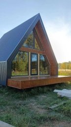 Дом А-фрейм с панорамным остеклением и деревянной террасой